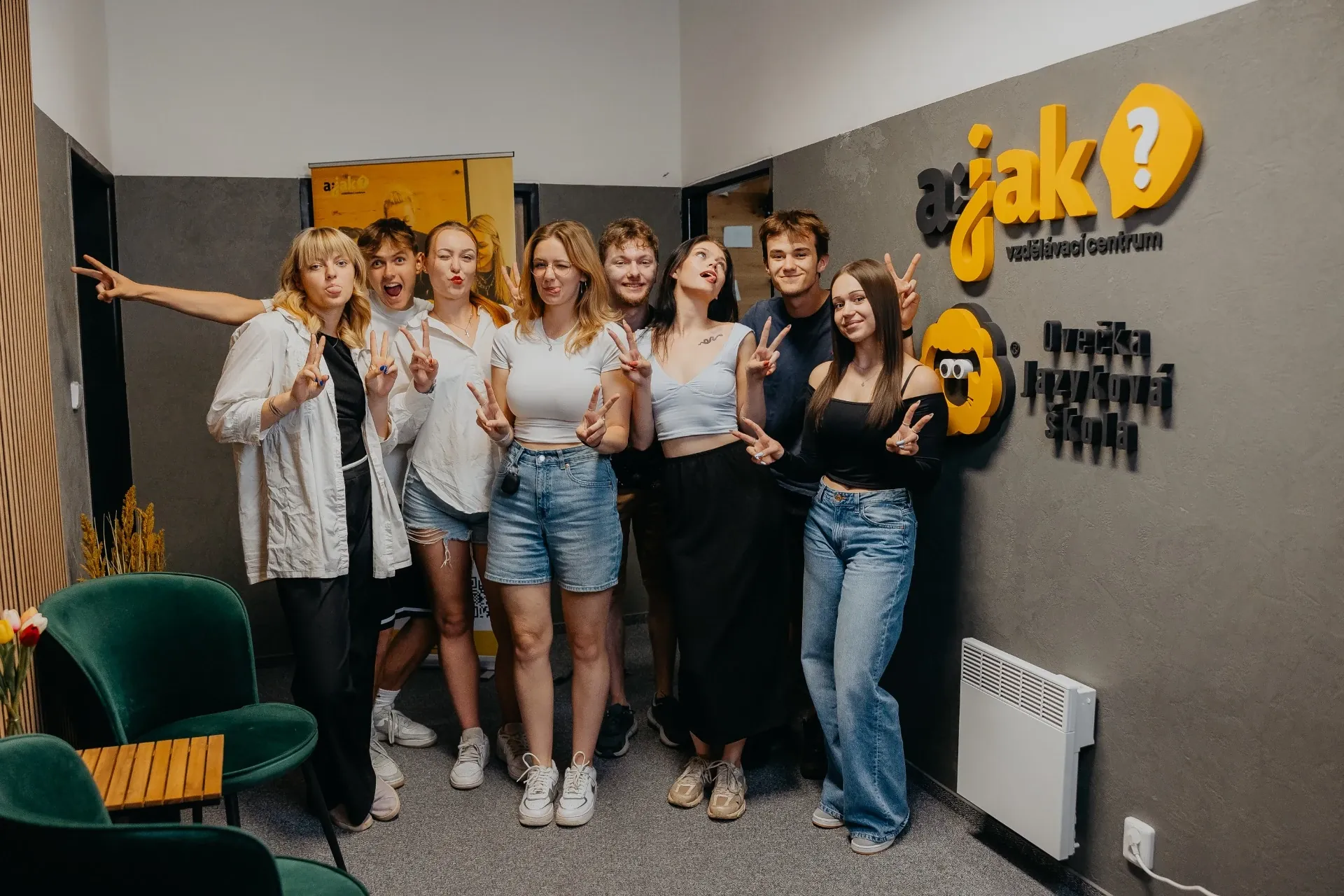 Parta studentů pomaturitního studia u loga AJAK Academy